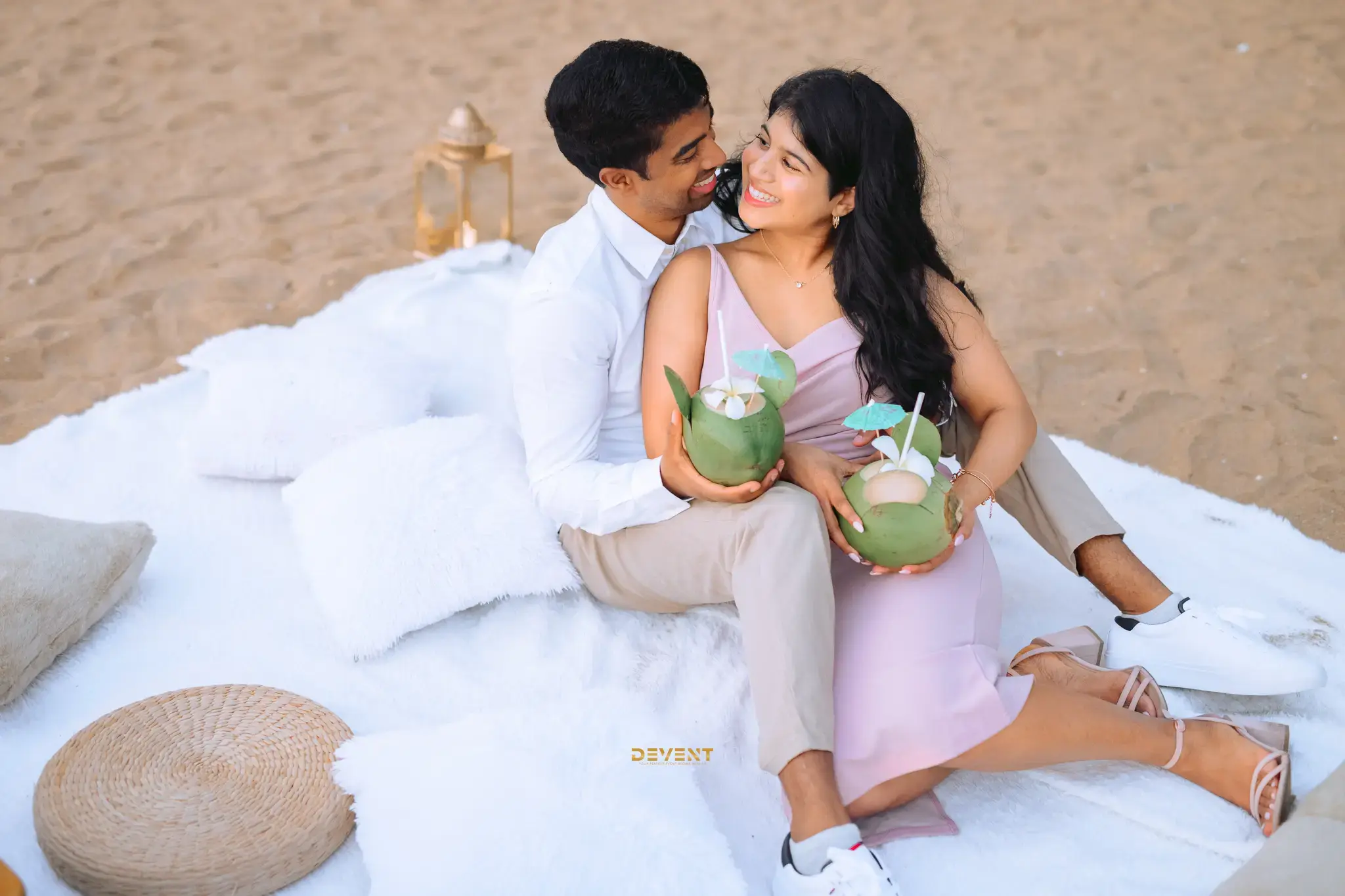 A couple sitting together in a sandy beach